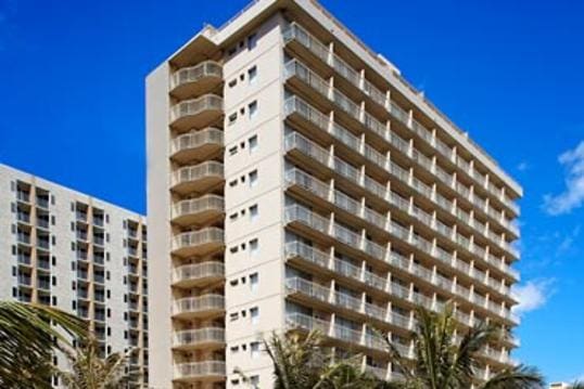 Tall apartment building with balconies.